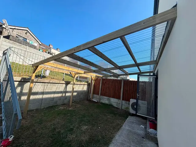 Large timber pergola with a clear roof spanning a yard in Fermoy, County Cork
